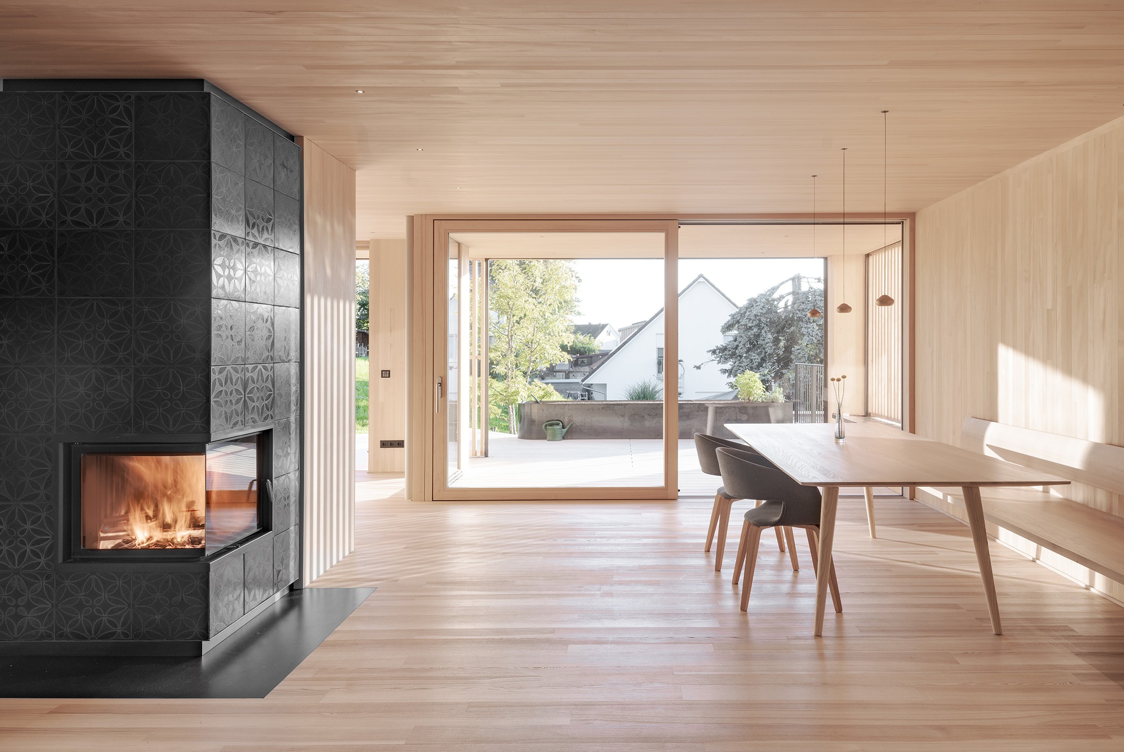 Ein Raum mit Kamin, Stühle, Tische und eine schöne Terasse