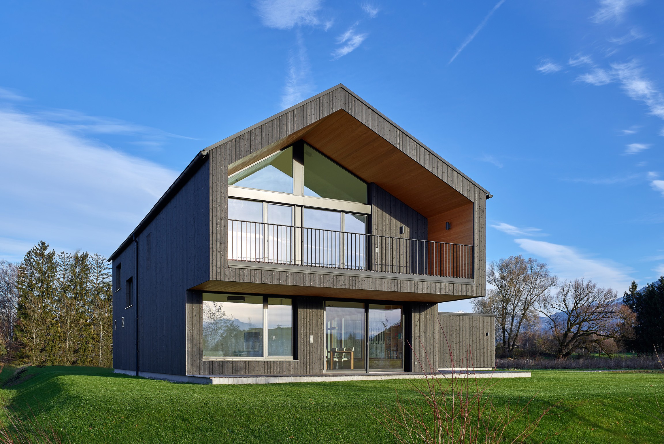 Der Baukörper präsentiert sich in einer dunkel gehaltenen Fassadenhaut, die dem Gebäude eine elegante, fast geheimnisvolle Ausstrahlung verleiht.