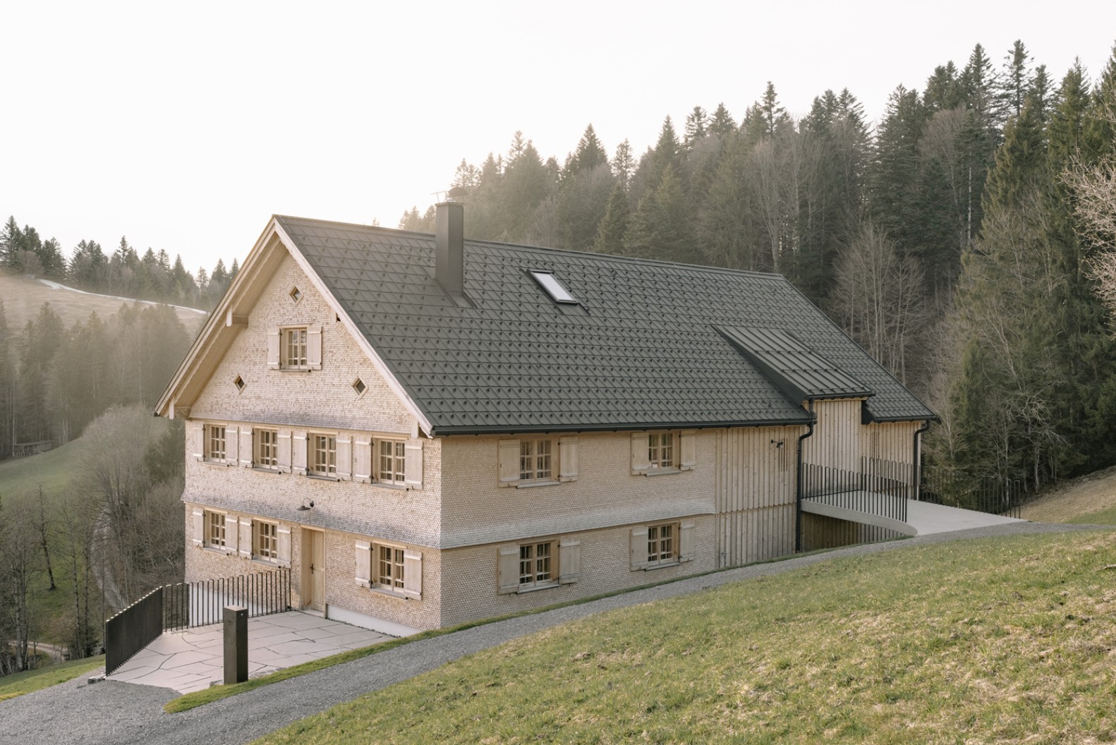 Das sanierte Wälderhaus Müller fügt sich harmonisch in die hügelige Landschaft ein.