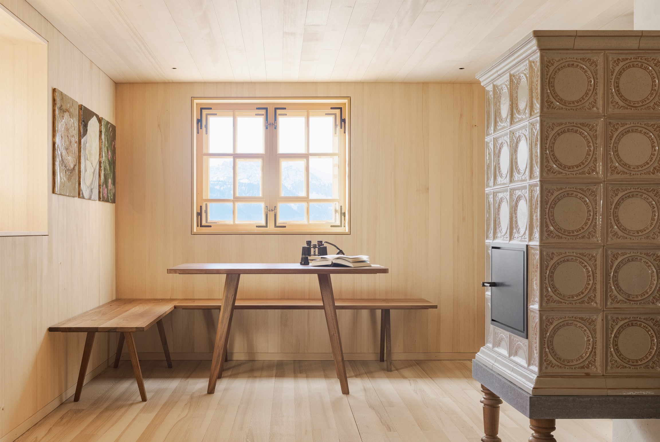 Im Inneren treffen klassisches Kassettentäfer und regionales Weißtannentäfer aufeinander und schaffen eine warme, ruhige Atmosphäre mit lokalem Charakter.