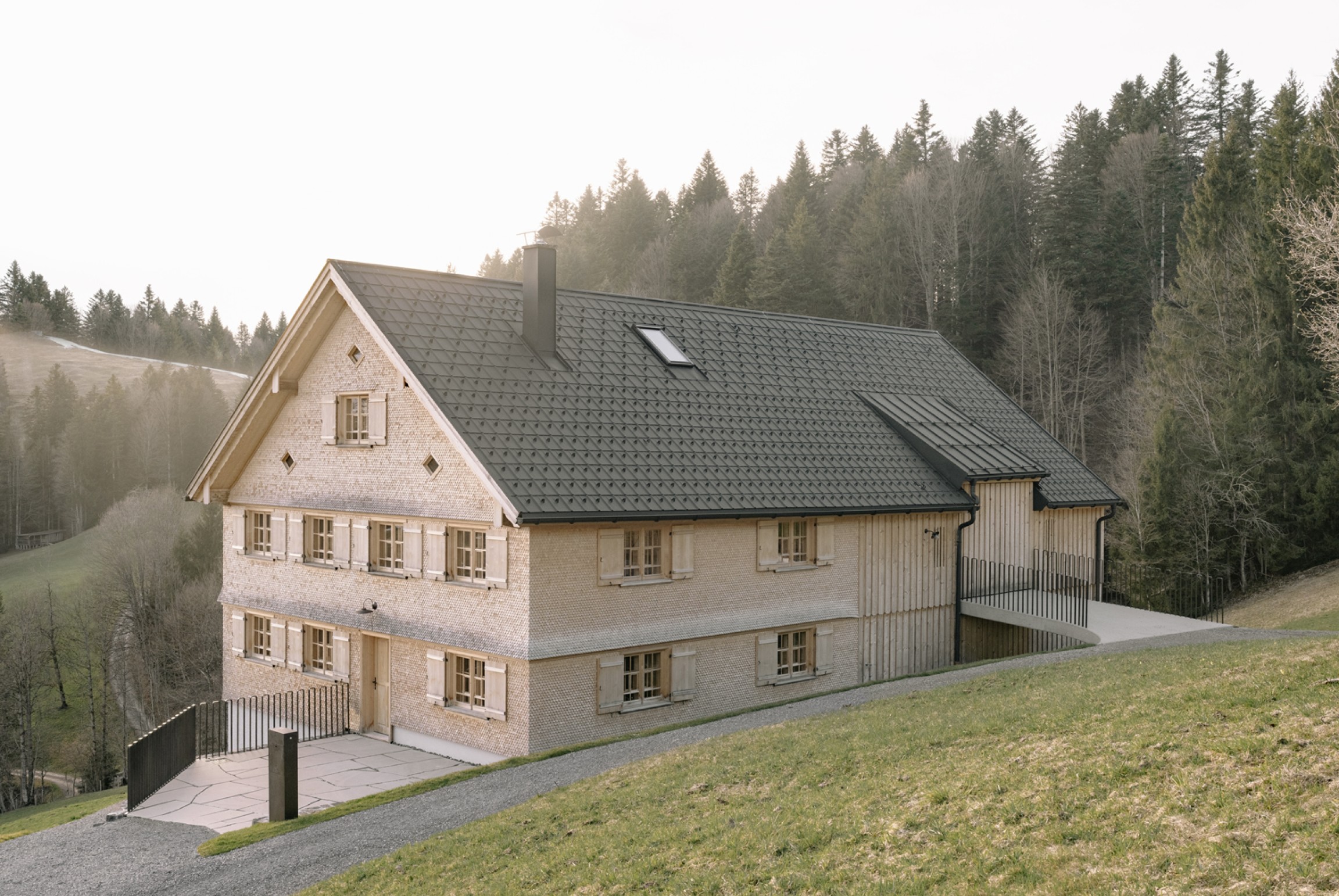 Das sanierte Wälderhaus Müller fügt sich harmonisch in die hügelige Landschaft ein.