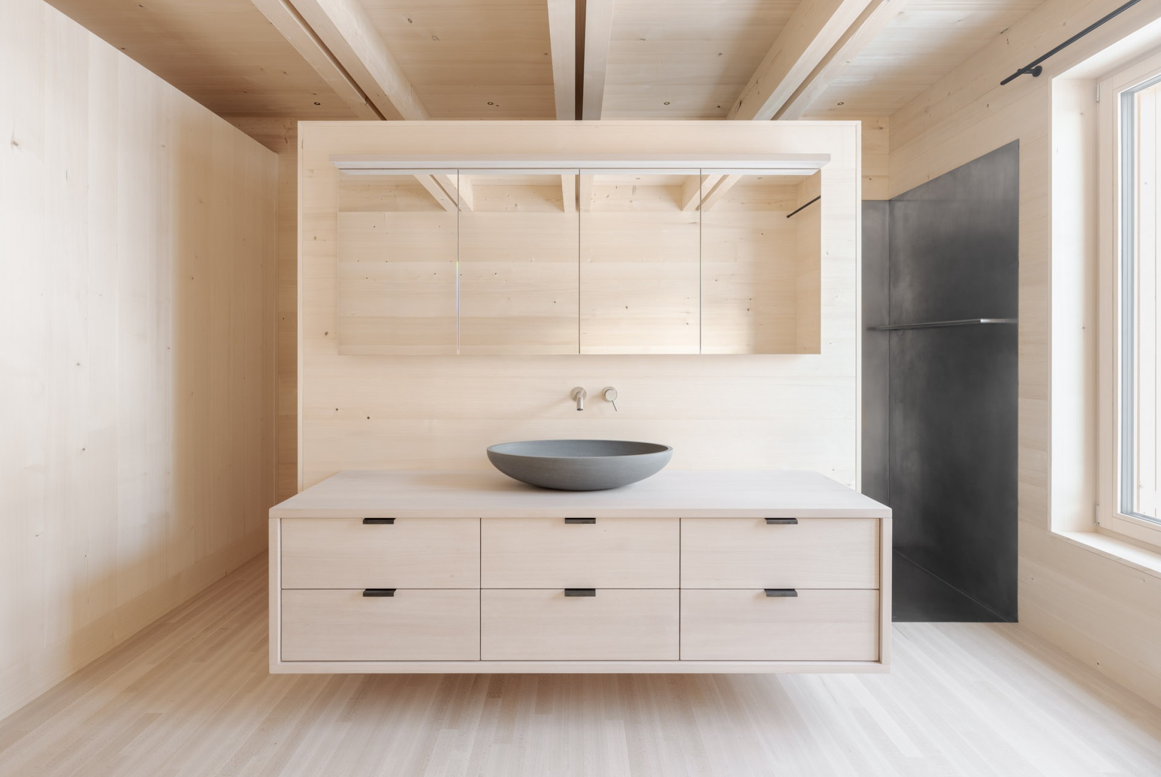 Eine Edelstahlwanne ersetzt die herkömmliche Dusche, Waschbecken aus Naturstein.