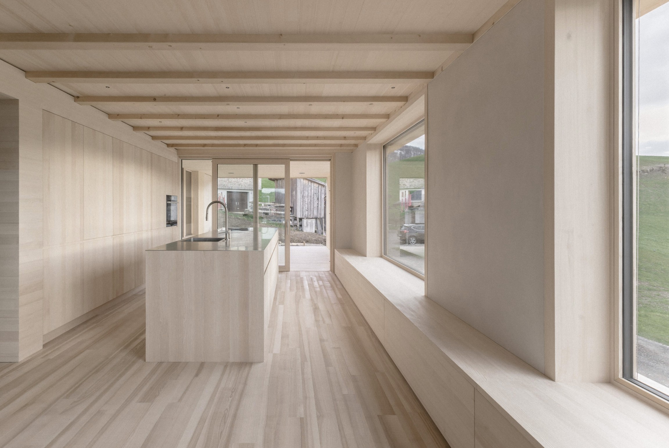 Möbelteile und Bodenbeläge aus massiver Esche setzen warme, lebendige Akzente im Innenraum.